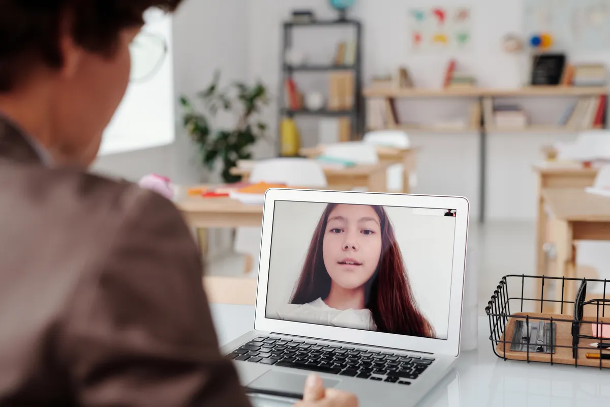 Docente dando una clase virtual desde su laptop